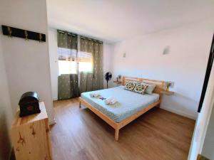 a small bedroom with a bed and a window at MarSolRosas in Hospitalet de l'Infant