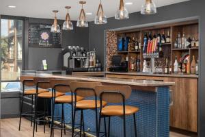 a bar with brown stools at a bar with a counter at Hotel Westport Kansas City, Tapestry Collection by Hilton in Kansas City