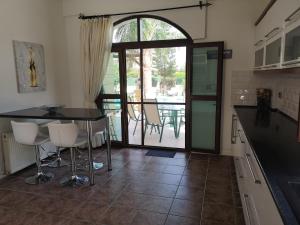 uma cozinha com mesa e cadeiras e um pátio em Stunning Private Villa - Beautiful Gardens & Pool em Lapithos