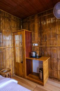 Habitación con cama y pared de madera. en Meraki Tribe Heritage, en Munnar