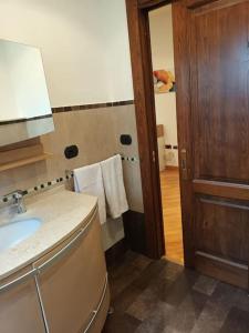 bagno con lavandino e porta in legno di La casa di Elenù a Posillipo a Napoli