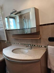 un bagno con lavandino e specchio di La casa di Elenù a Posillipo a Napoli Altre 18 foto