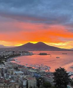 un tramonto su una città con una montagna sullo sfondo di La casa di Elenù a Posillipo a Napoli