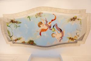 a ceiling with a mural of cherubs at Hotel Maximus in Rome