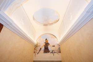 um quarto com uma pintura de um homem no tecto em Hotel Maximus em Roma