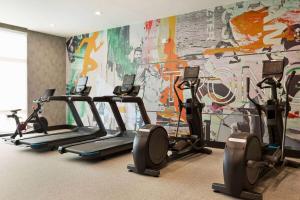 einem Fitnessraum mit mehreren Laufbändern vor einem Wandbild in der Unterkunft Hawthorn Extended Stay by Wyndham Mount Laurel Moorestown in Mount Laurel