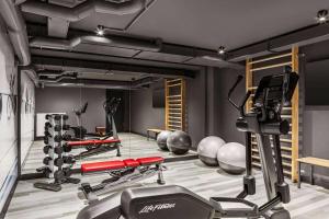 Un gimnasio con varios equipos de ejercicio en una habitación. en Vienna House Easy by Wyndham Bremen City Apartments, en Bremen