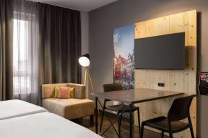 Una televisión o centro de entretenimiento en Vienna House Easy by Wyndham Bremen City Apartments