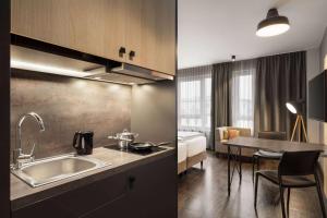 Una cocina con fregadero y una habitación con cama. en Vienna House Easy by Wyndham Bremen City Apartments, en Bremen 37 fotos más