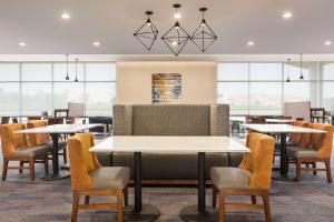 a restaurant with tables and chairs and windows at La Quinta Inn & Suites by Wyndham Mount Laurel Moorestown in Mount Laurel