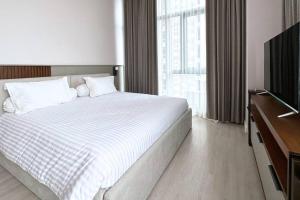 ein Hotelzimmer mit einem Bett und einem TV in der Unterkunft Deluxe 2 BR Condo in Central Jakarta in Jakarta