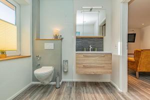 ein Badezimmer mit einem WC, einem Waschbecken und einem Spiegel in der Unterkunft fewo1846 - App Westerland - komfortable Wohnung mit 3 Schlafzimmern im 1 OG in Flensburg