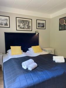 um quarto com uma cama azul com duas almofadas em Hankø Hotell & Spa em Gressvik