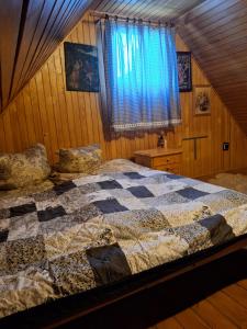1 dormitorio con 1 cama con edredón en Chata Vlkolínec, en Ružomberok