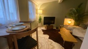 salon ze stołem i telewizorem w obiekcie L'annexe spa du Tropical Lodge w mieście Narbona