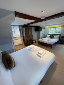 a bedroom with two beds and a living room at Rylands Farm Guest House in Wilmslow