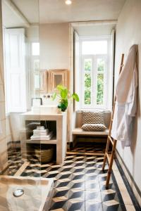 W łazience znajduje się umywalka i lustro. w obiekcie Vila Branca Guesthouse - Palacete w mieście Figueira da Foz