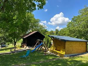 uma cabana com escorrega e um parque infantil em Holiday home DEDINA HIŽICA em Sveti Urban
