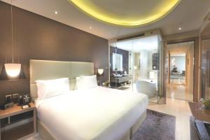 a bedroom with a large white bed and a living room at PARAMOUNT Hots & residential property in Dubai