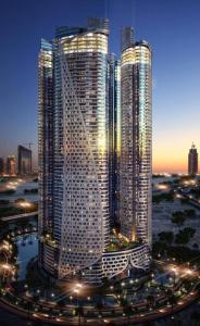 two tall skyscrapers in a city at night at PARAMOUNT Hots & residential property in Dubai