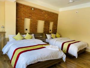 - 2 lits dans une chambre avec un mur en briques dans l'établissement Hotel Highway 75, à Benighāt