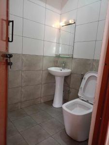 La salle de bains est pourvue de toilettes et d'un lavabo. dans l'établissement Hotel Highway 75, à Benighāt