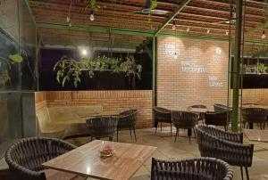 a restaurant with tables and chairs and a piano at Touchwood Bliss Igatpuri in Nashik
