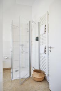 a bathroom with a glass shower and a basket at Weinforum Franken Hotel & Restaurant in Eibelstadt