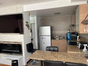 キトにあるHermosa Suite inteligente con Jacuzziのキッチン(冷蔵庫、テーブル、椅子付)