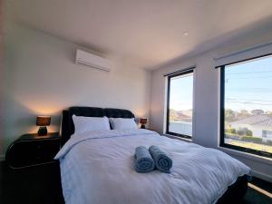 阳光海岸Brand new house - Mordern home and great location的一间卧室配有一张带2条蓝色毛巾的床