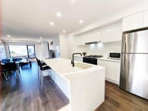 a kitchen with white cabinets and a stainless steel refrigerator at Brand new house - Mordern home and great location in Sunshine