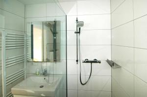 a white bathroom with a shower and a sink at Mittelberg Ferienwohnung in Mittelberg