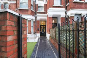 a black fence in front of a brick building at Spacious 1 bedroom flat in London