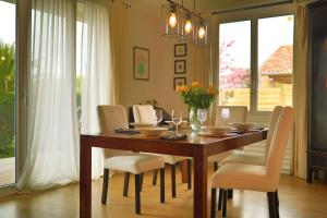 een eettafel met witte stoelen en een eetkamer bij Jolie villa avec piscine chauffée in Anglet