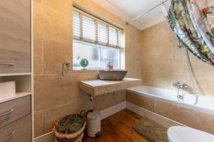 a bathroom with a sink and a tub and a window at 58D Earlham Road in Norwich