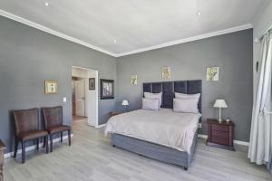 豪特灣的住宿－Seaside Villa - 1 La Mer，一间卧室配有一张大床和两把椅子