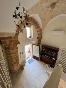 una camera con un muro in pietra e un lampadario a braccio di Handy Margherita a Brindisi