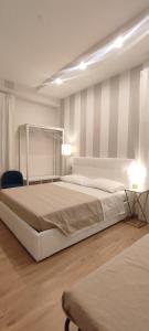a white bedroom with a large bed and a chair at Portonaccio suite - Stazione Tiburtina - Università - Metro B in Rome