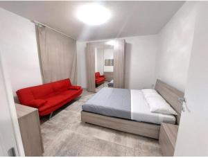 een slaapkamer met een bed en een rode bank bij Sweet Mira in Mira