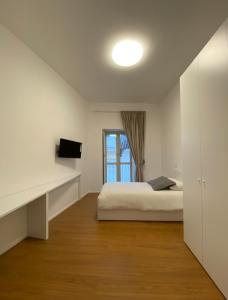 een witte slaapkamer met een bed en een raam bij Aversa Exclusive private room in Aversa