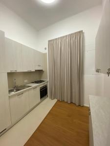 een keuken met witte kasten, een wastafel en een tafel bij Aversa Exclusive private room in Aversa