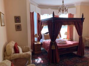 a bedroom with a canopy bed and a chair at The Redcliffe Hotel in Scarborough