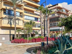 a building with palm trees and flowers in a courtyard at Hanami Avenida de España in Estepona