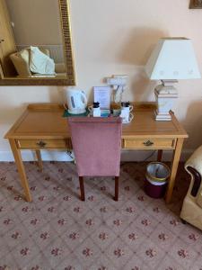 a desk with a lamp and a table with a chair at The Redcliffe Hotel in Scarborough
