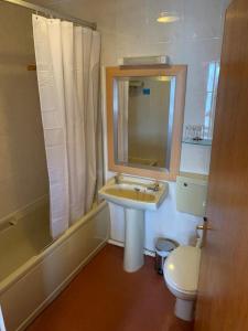 a bathroom with a sink and a toilet and a mirror at The Redcliffe Hotel in Scarborough