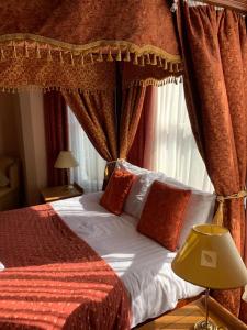 a bedroom with a canopy bed with red sheets and pillows at The Redcliffe Hotel in Scarborough