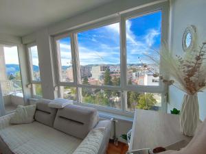 a living room with a couch and large windows at Stan na dan Bella in Banja Luka