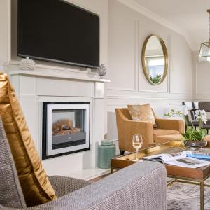 uma sala de estar com lareira e televisão de ecrã plano em The Lodges at Glenlo Abbey Hotel and Estate em Galway