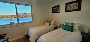 a bedroom with two beds and a window at Central Coast Jetty House in Saratoga