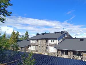 a large house with a black roof at Näköalahuoneisto 324 in Syöte